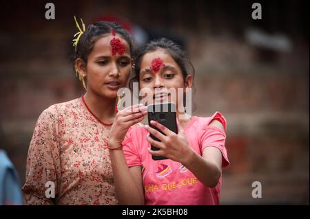 Kathmandu, Bagmati, Nepal. 7th Oct, 2022. Small girls gesture as they make video after receiving Tika on forehead and jamara during Dashain festival on October 7, 2022. (Credit Image: © Sunil Sharma/ZUMA Press Wire) Stock Photo