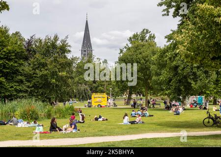 Young people enjoy the beautiful weather on the lawn in the Vondelpark in Amsterdam. Stock Photo