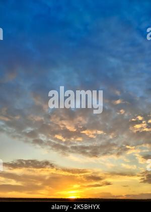 Abstraction of colorful orange and blue clouds in the sky during sunset. Stock Photo