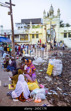 Mumbai, Maharashtra, India : Beggars line on the causeway leading to the 19th century Haji Ali Dargah and mosque (in background) which contains the to Stock Photo