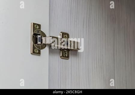 Furniture door hinge on white door Stock Photo