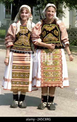 Maieru, Bistrița-Năsăud County, Romania, 2000. Young girls in beautiful traditional folk costumes, wearing 'opinci', a handmade leather footwear. Stock Photo