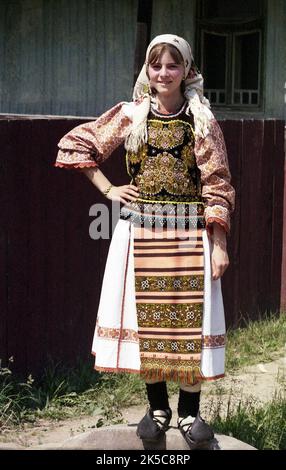 Maieru, Bistrița-Năsăud County, Romania, 2000. Young girl in beautiful traditional folk costume, wearing 'opinci', a handmade leather footwear. Stock Photo