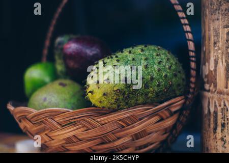 Basket of fruits with Soursop in focus (AKA custard apple, graviola, guyabano, guanabana, Brazilian paw paw) which help in digestion, fight cancer. Stock Photo