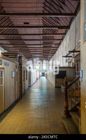 Germany, Lubeck - July 13, 2022: Heiligen Geist Hospital. Look into hospital ward along individual cabins under brown wooden roof Stock Photo