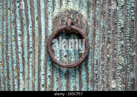 Rusty door knocker on a wooden door. Stock Photo
