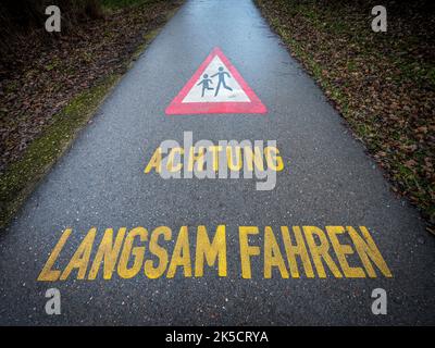 Road, traffic sign, pictogram, pedestrian, writing, attention, drive slowly Stock Photo