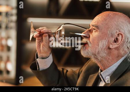 People drinking wine and eating cold cut meat in a wine cellar. Stock Photo