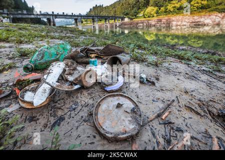 Italy, Veneto, province of Belluno, Centro Cadore lake. Environmental pollution from garbage and plastic emerged with the withdrawal of water from the lake Stock Photo