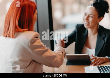 Business women shake hands while arranging a business Stock Photo