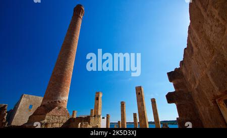 Italy, Sicily, east coast, bird sanctuary Vendicari, ruins of a tonnara, tuna processing factory, stone columns and a round chimney rise into the deep blue sky, super wide angle shot Stock Photo