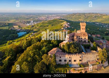 Aerial view of the Cigognola castle and vineyards at sunset. Cigognola