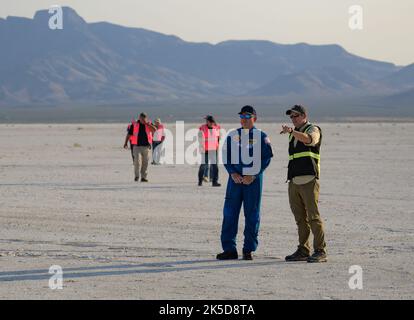 NASA astronaut Butch Wilmore, and Boeing Starliner Launch Conductor Louis Atchison, right, watch as Boeing and NASA teams work around Boeing’s CST-100 Starliner spacecraft after it landed at White Sands Missile Range’s Space Harbor, Wednesday, May 25, 2022, in New Mexico. Boeing’s Orbital Flight Test-2 (OFT-2) is Starliner’s second uncrewed flight test to the International Space Station as part of NASA's Commercial Crew Program. OFT-2 serves as an end-to-end test of the system's capabilities. Stock Photo