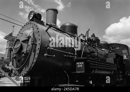 Vintage black steam train parked on tracks at the train museum in historic Lowell, Massachusetts. The image was captured on black and white analog fil Stock Photo