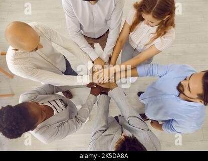 Top view of team of happy multiracial business people stacking their hands together Stock Photo