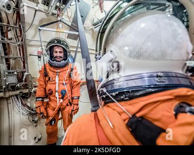 Engineers at NASA Johnson Space Center test Orion spacesuits in a thermal vacuum chamber to confirm life support, pressure integrity, and spacewalk capability for deep space missions. Stock Photo
