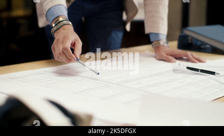 Close-up of engineers team studying blueprints and papers, discussing new technologies and business strategy, working on engineering startup project in office room. Teamwork and brainstorming Stock Photo