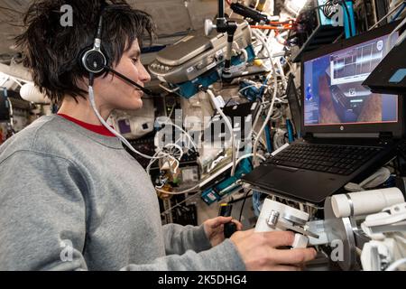 ESA astronaut Samantha Cristoforetti, serving on Expedition 67, practices robotics maneuvers using a laptop inside the ISS Columbus laboratory module. Stock Photo