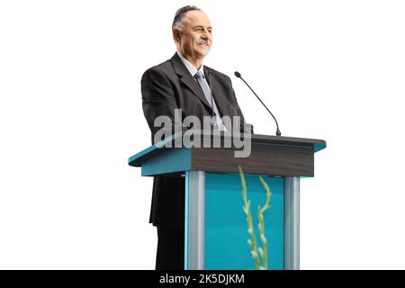 Mature businessman giving a speech on a podium and smiling isolated on white background Stock Photo