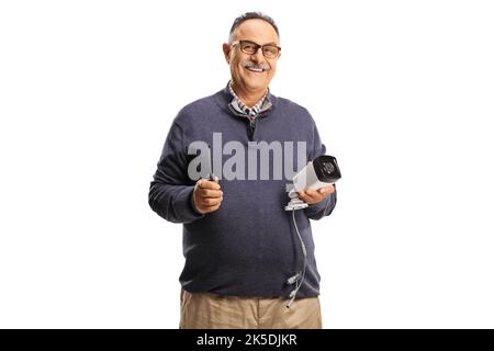Elderly man holding a cctv camera and a screwdriver and smiling isolated on white background Stock Photo