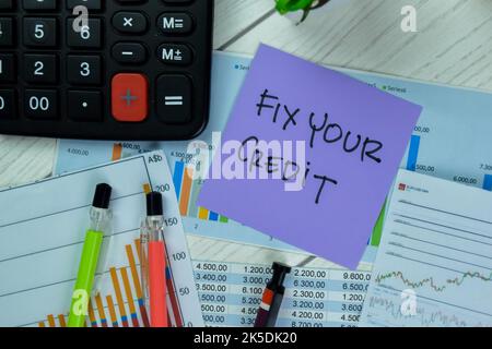 Concept of Fix Your Credit write on sticky notes isolated on Wooden Table. Stock Photo