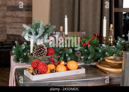Elegant Christmas dinner table setting. Decoration of Christmas table: candles, juniper branches and napkins, wooden plates. New Year decorations in Stock Photo