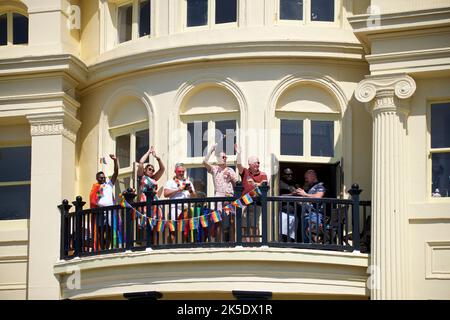 Brighton & Hove Pride Festival, Brighton & Hove, East Sussex, England. Locals looking on from the Regency architecture of Brunswick Terrace, Hove. Stock Photo