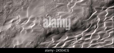 Martian landscape. This HiRISE image shows a dune field in Lower Syrtis Major, Mars.White ripples on dark surface, as well as wind streaks from small craters (to the west) as also visible in a Mars Orbiter Camera image. Our interest is to see if new dust deposited or removed. This observation can give us a better understanding of the mechanisms of streak and dune/ripple initiation.Image is less than 5 km (3 mi) across A unique optimised version of NASA imagery. Credit: NASA/JPL/UArizona Stock Photo