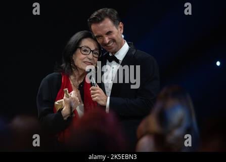 Leipzig, Germany. 07th Oct, 2022. Singer Nana Mouskouri stands next to presenter Florian Silbereisen during the 'Goldene Henne' media award ceremony in Leipzig. Mouskouri was honored in the lifetime achievement category. The award is given to stars from music, sports and show business. Credit: Hendrik Schmidt/dpa/Alamy Live News Stock Photo