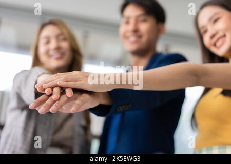 Group of Asia young entrepreneurs creative people join hand and excited for success project, working together in the office. Stratup business team dis Stock Photo