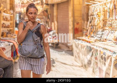 Insecure tourist strolling through a street market in Cairo Stock Photo