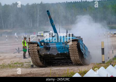 ALABINO, RUSSIA - AUGUST 19, 2022: Tank T-72B3 in the blue coloration of the Abkhaz team comes out of the ditch. Fragment of tank biathlon. Internatio Stock Photo