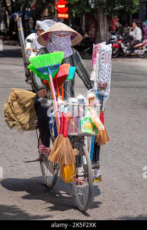 Street vendor wearing bamboo hat with bicycle, Hai Phong, Vietnam Stock Photo