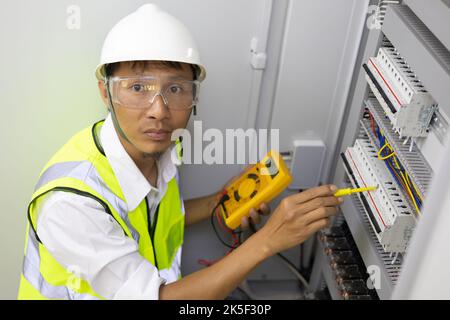 Male engineer checking electrical system with electronic equipment Stock Photo