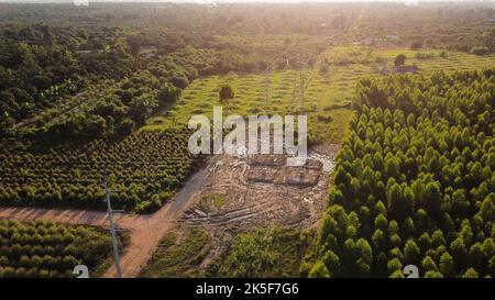 Aerial view of high voltage pylon foundation construction site. Top view of construction of power lines in the forest. Stock Photo