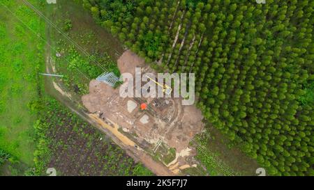 Aerial view of excavators are working on the foundations of high-voltage pylons and the legs of high-voltage poles. Top view of construction of power Stock Photo