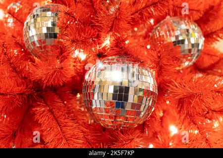Christmas disco ball with a red bow on the Christmas tree. new Year's background. Decorated Christmas tree. Stock Photo