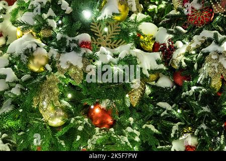 New Year's decoration balls on a snowy branch. Christmas tree toy on the branches of spruce covered with snow. spruce branches covered with snow on th Stock Photo