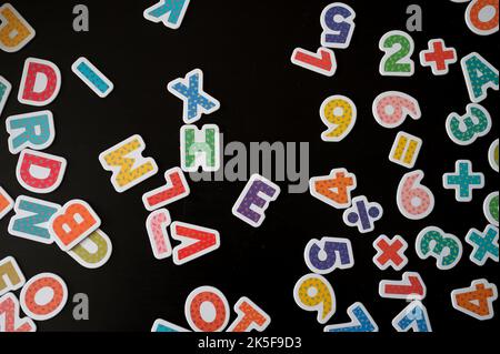 Top view of numbers and letters against black background Stock Photo