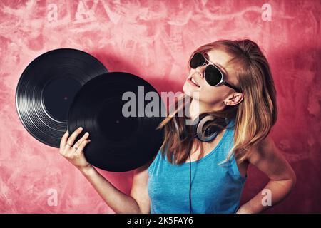 Her music is as colourful as her personality. A smiling young dj holding two records. Stock Photo