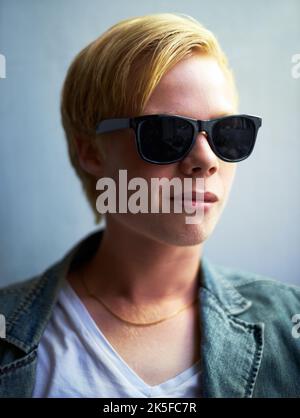 Too cool. Portrait of an attractive young guy wearing hipster shades. Stock Photo