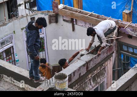 22 June 2022, Darjeeling, India, undefined construction worker constructing or building wall by placing bricks and cement in darjeeling, India - conce Stock Photo