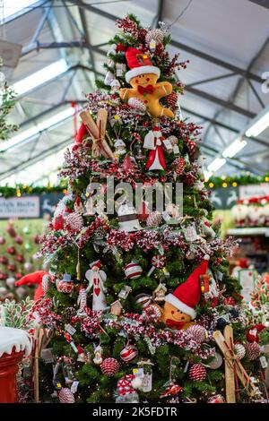 Christmas tree packed with decorations and novelties on display in a retail store Stock Photo