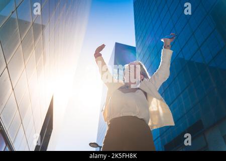 Happy business woman celebrating success with raised arms. Stock Photo