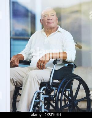 Retirement, window and elderly man in wheelchair thinking about life in luxury Portugal nursing home, estate or village. Senior Care, disability and Stock Photo