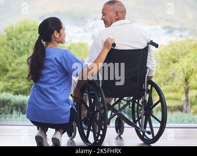 Healthcare, disability and man in wheelchair with nurse on retirement or nursing home patio. Senior care, happy disabled grandpa and woman caregiver Stock Photo