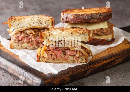 Homemade Cheesy Patty Melt Sandwich with Cheese and Onions closeup on the wooden board on the table. Horizontal Stock Photo