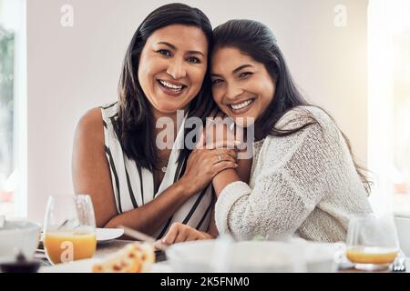 Family, love and mother with her adult daughter at home, eating food and enjoying time together. Love, bonding and lunch with a mature female sitting Stock Photo