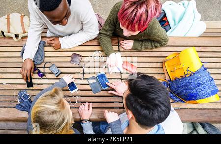 Top view of multiracial friends using mobile smart phone - Addiction concept with young people on new tech devices - Multicultural students having fun Stock Photo