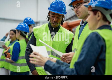 Team of multiracial engineers working in robotic factory - Tech industry concept Stock Photo